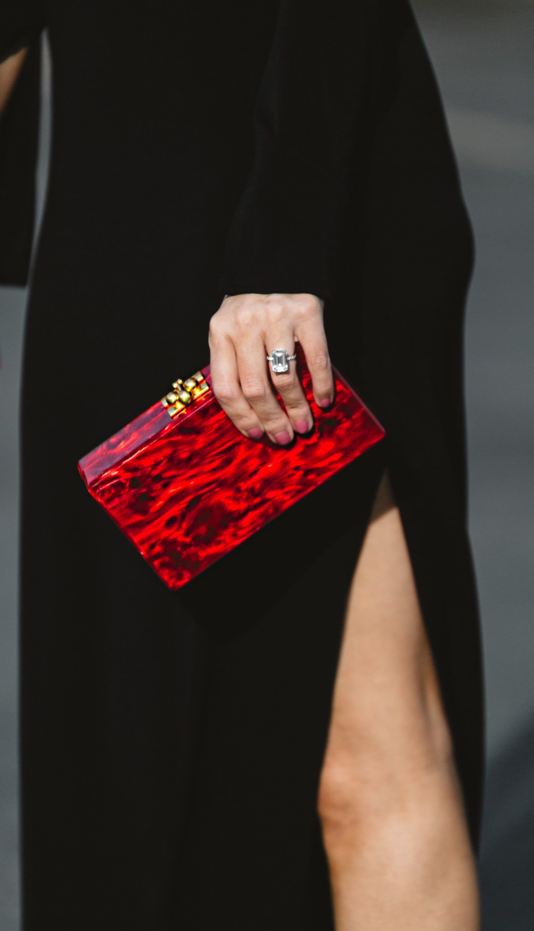 a red clutch pairs perfectly with a little black dress