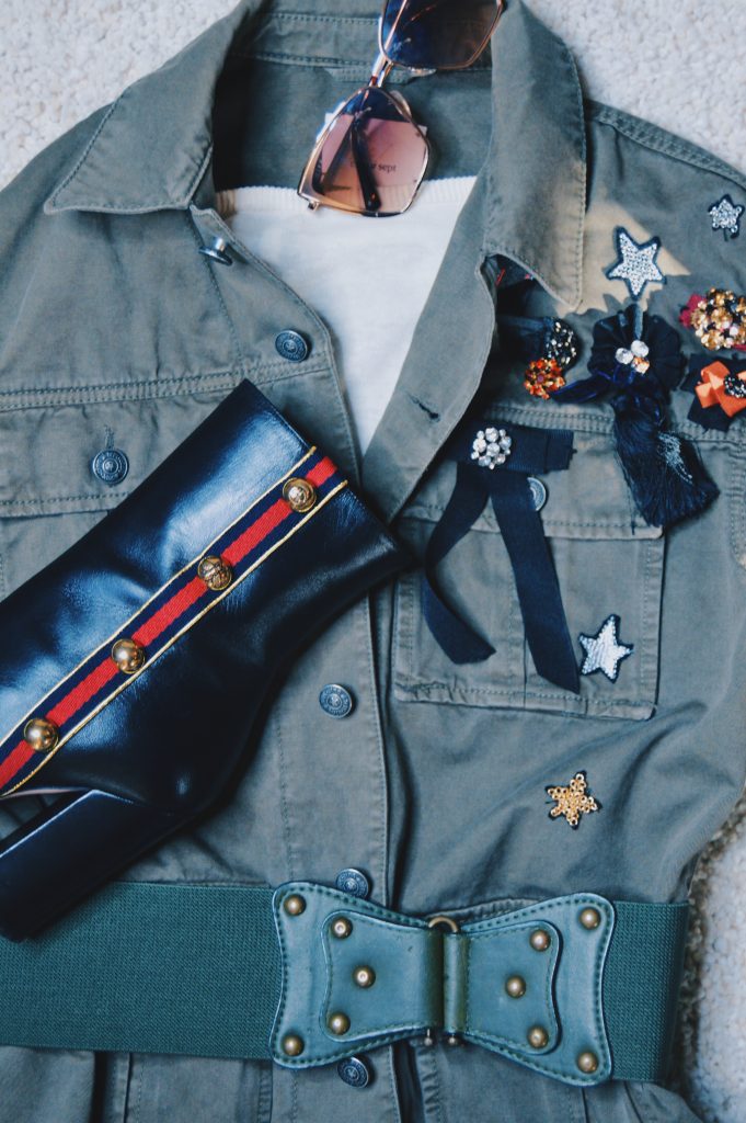 flat lay of black booties, one of my essential belts, and a green army jacket