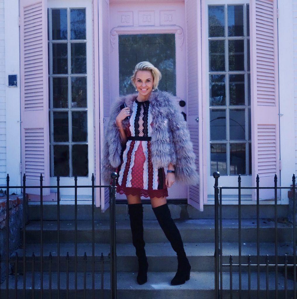 happy pink outfit on woman standing outside of house