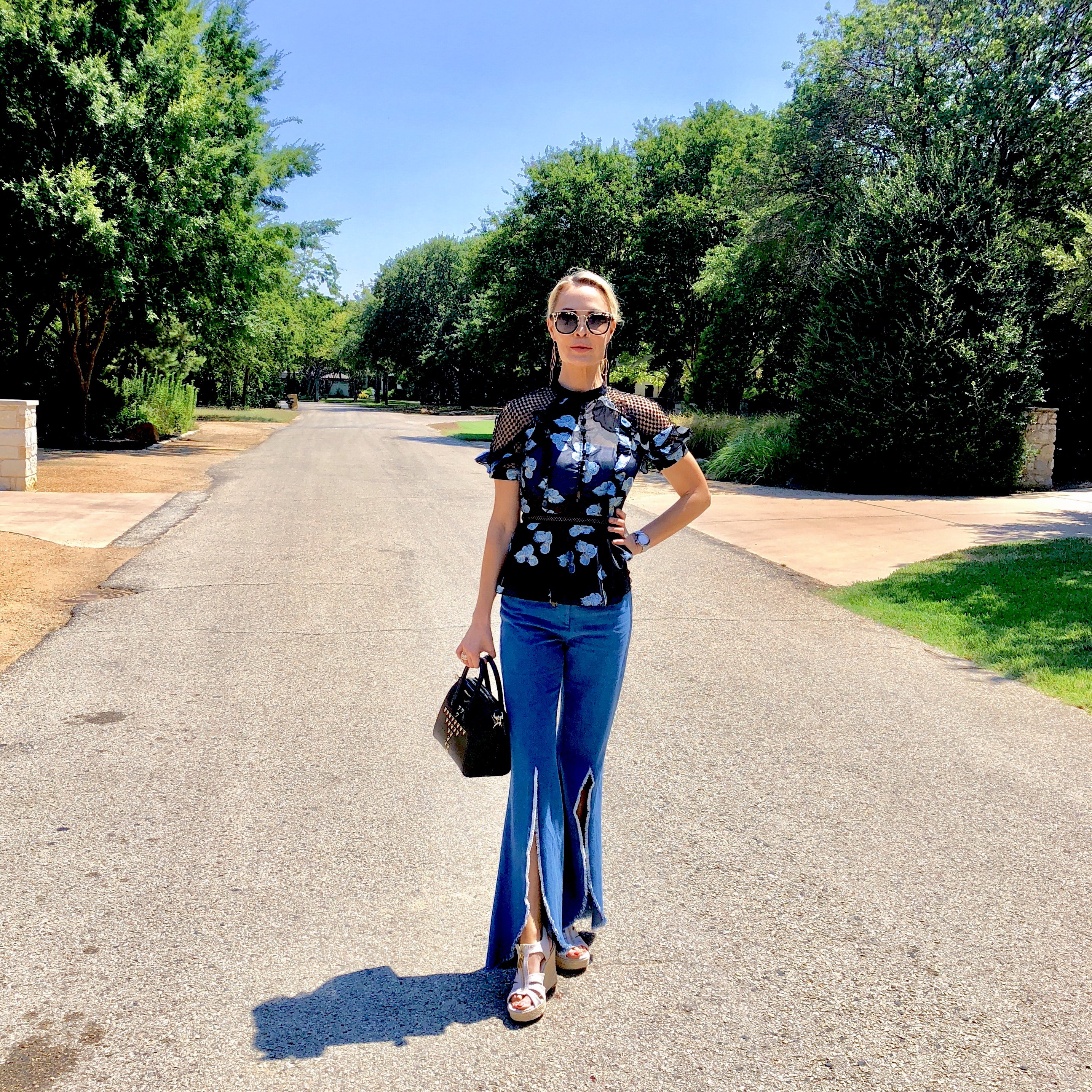 black box leather satchel with flared, retro jeans