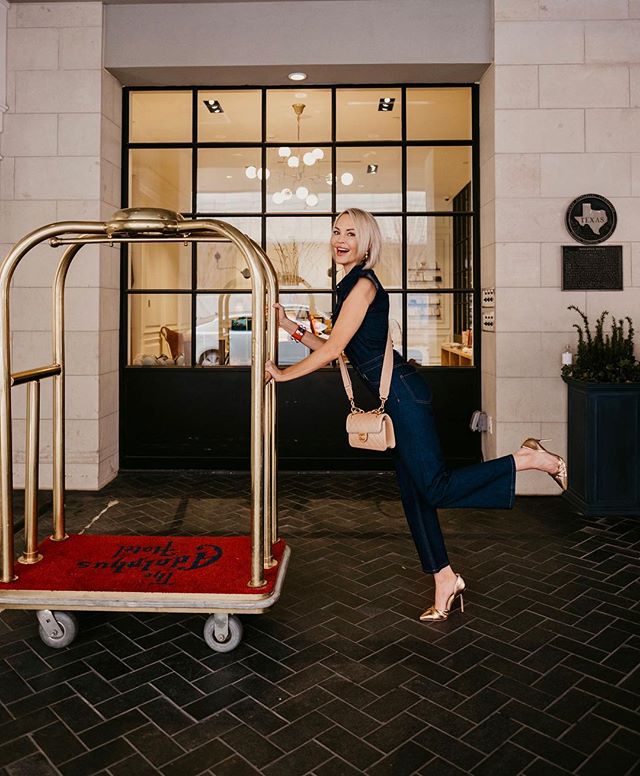 Whitney standing in front of a hotel with a luggage cart