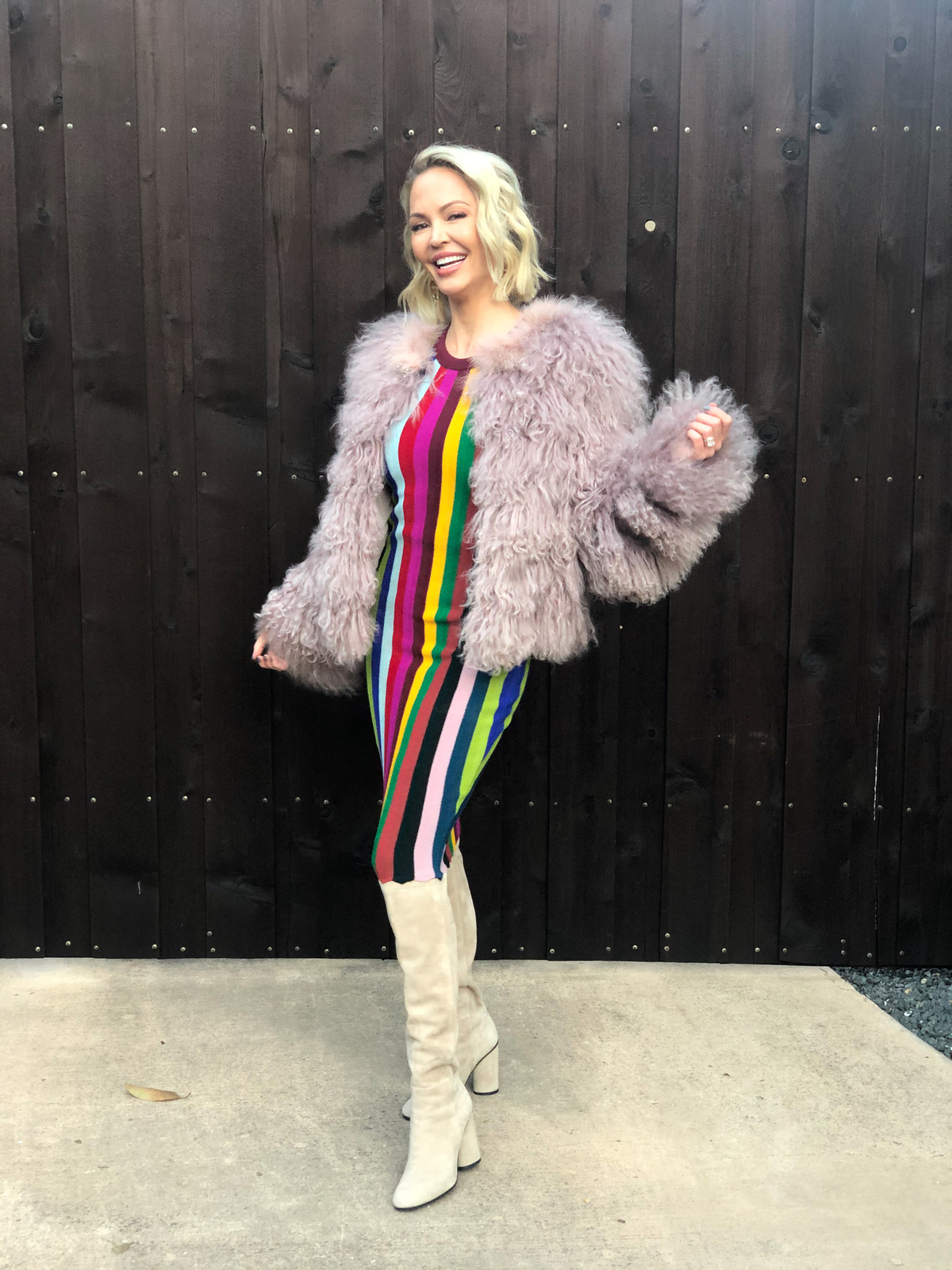 posing in colorful striped dress and knee-high boots